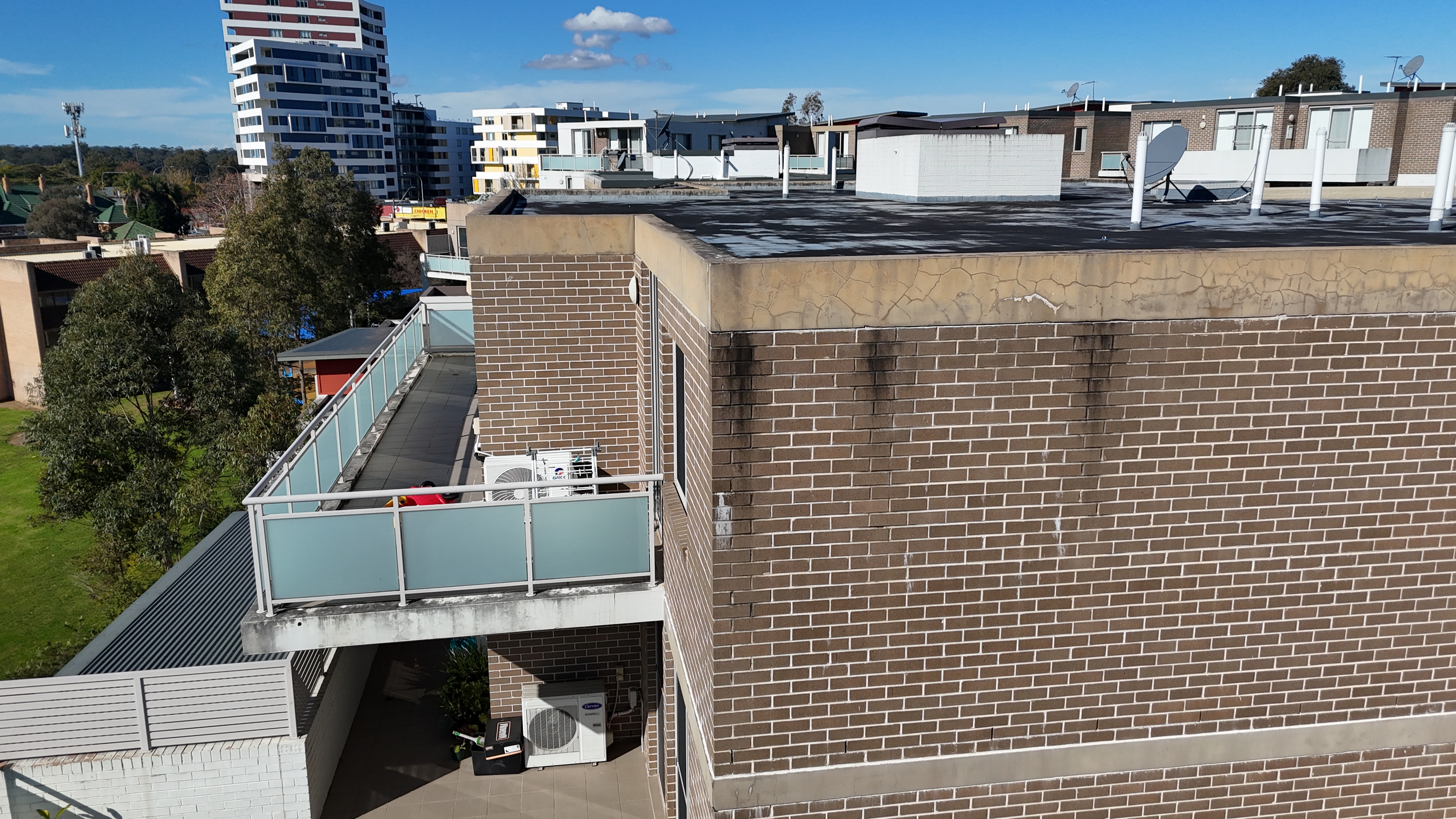 Drone condition image showing a residential roof edge, parapet and façade